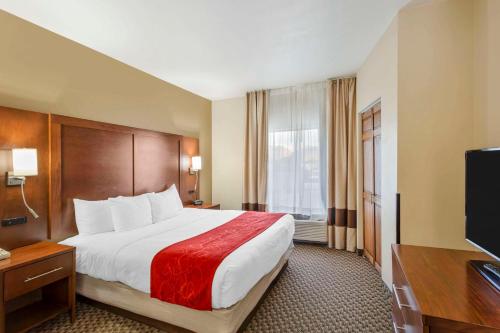 a hotel room with a bed and a flat screen tv at Comfort Suites Ogden Conference Center in Ogden