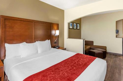 a hotel room with a large bed and a chair at Comfort Suites Ogden Conference Center in Ogden