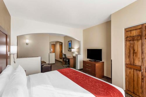 a hotel room with a bed and a flat screen tv at Comfort Suites Ogden Conference Center in Ogden