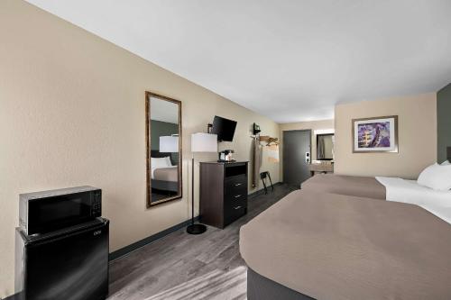 a hotel room with two beds and a television at Quality Inn Fort Myers Cape Coral in Fort Myers
