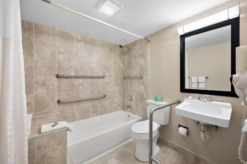 a bathroom with a tub and a toilet and a sink at Quality Inn Fort Myers Cape Coral in Fort Myers