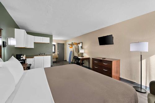 a hotel room with a large bed and a kitchen at Quality Inn Fort Myers Cape Coral in Fort Myers