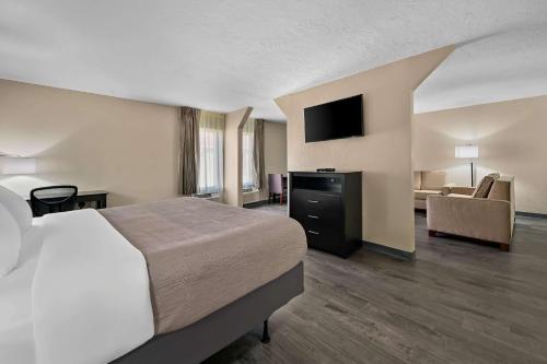 a hotel room with a bed and a couch at Quality Inn Fort Myers Cape Coral in Fort Myers