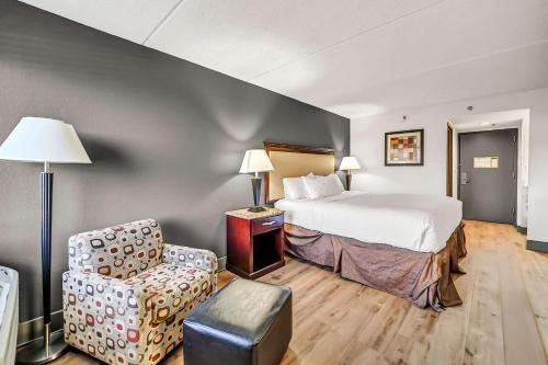 a hotel room with a bed and a chair at Radisson Hotel Schaumburg in Schaumburg