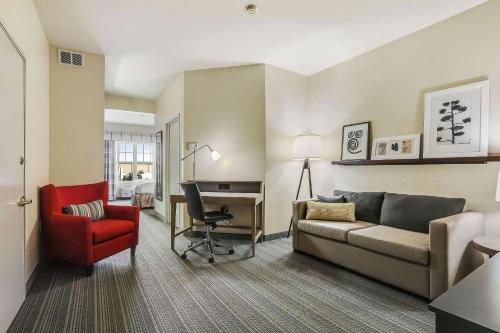 a living room with a couch and a desk at Country Inn & Suites by Radisson, Green Bay, WI in Ashwaubenon