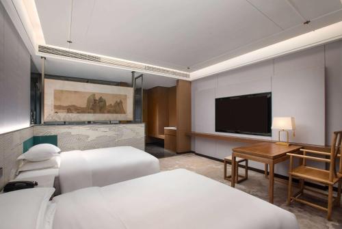 a hotel room with two beds and a flat screen tv at Days Hotel by Wyndham Luzhou Gulin in Gulin