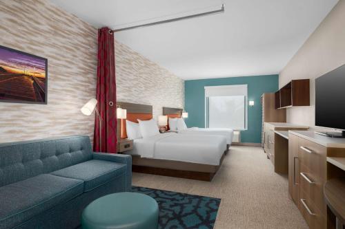 a hotel room with a bed and a couch at Home2 Suites By Hilton Virginia Beach Princess Anne in Virginia Beach