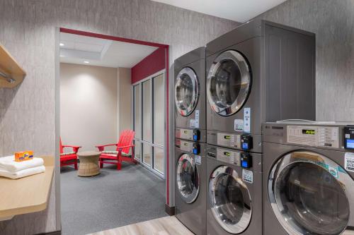 a laundry room with four washing machines in a room at Home2 Suites By Hilton Virginia Beach Princess Anne in Virginia Beach