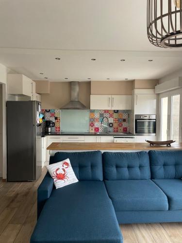 un salon avec un canapé bleu dans une cuisine dans l'établissement La Wimereusiènne, à Wimereux