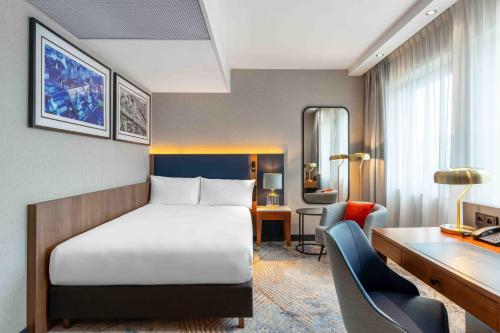 a hotel room with a bed and a desk at Wyndham Wroclaw Old Town in Wrocław