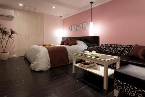 a bedroom with a bed and a couch and a table at ホテルシック in Kobe