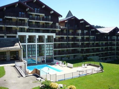 un grand bâtiment avec une piscine devant dans l'établissement Magnifique Duplex de 56m2 pour 6 Personnes, à Praz de Lys - Sommand