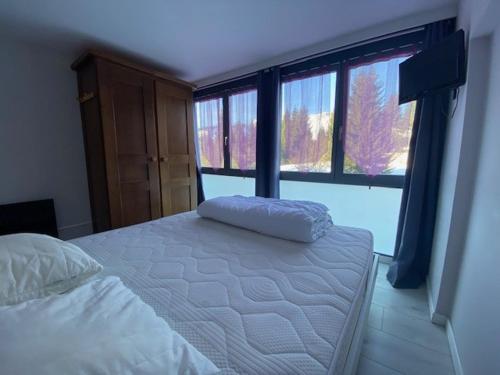 une chambre avec un lit et une grande fenêtre dans l'établissement Magnifique Duplex de 56m2 pour 6 Personnes, à Praz de Lys - Sommand