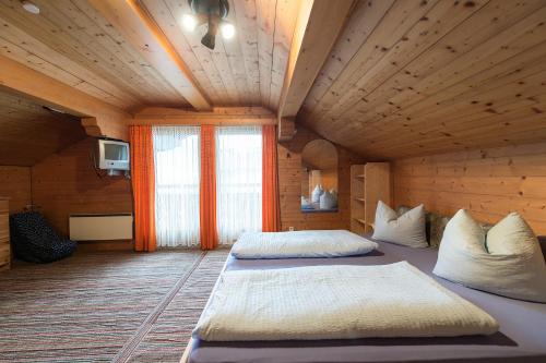 カルテンバッハにあるFerienwohnungen Juttaの木製の部屋にベッド2台が備わるベッドルーム1室