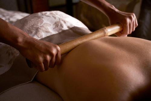a pregnant woman holding a baseball bat on her lap at Anantara Lawana Koh Samui Resort in Chaweng