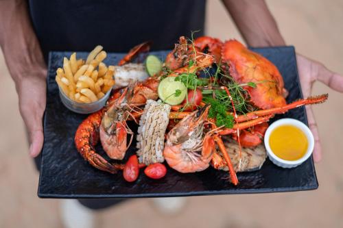 a plate of food with lobster and french fries at Club Palm Bay in Marawila