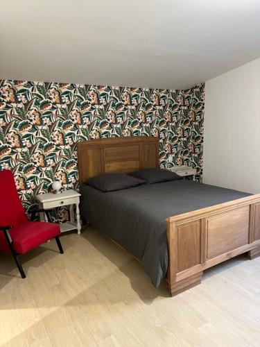 una camera da letto con un letto e una sedia rossa di Chez Marie et Dany a Châteaumur