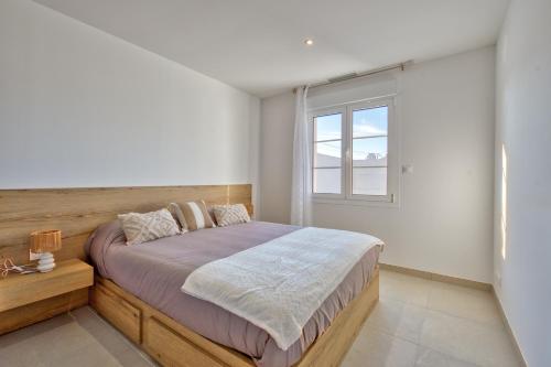 une chambre avec un grand lit et une fenêtre dans l'établissement Maison Corail 1 - Climatisation jardin et parking, à Saint-Pierre-dʼOléron