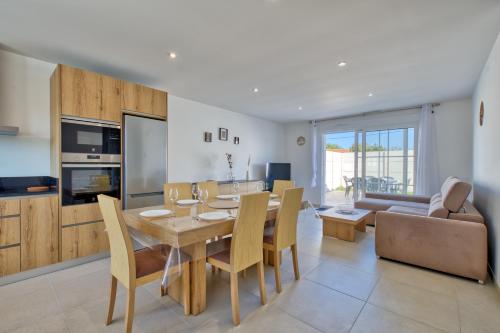 une cuisine et une salle à manger avec une table et des chaises dans l'établissement Maison Corail 1 - Climatisation jardin et parking, à Saint-Pierre-dʼOléron