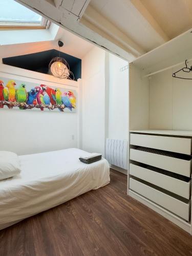 une chambre avec un lit et un tableau au mur dans l'établissement Artemis, à Caen