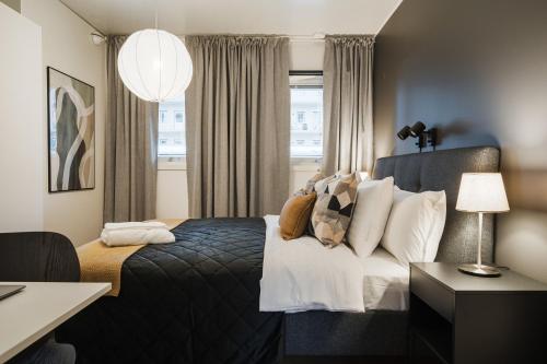 a hotel room with a bed and a window at Guestly Homes - 1BR Scandinavian Comfort in Piteå