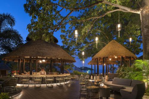 a restaurant with tables and chairs and umbrellas at Anantara Lawana Koh Samui Resort in Chaweng