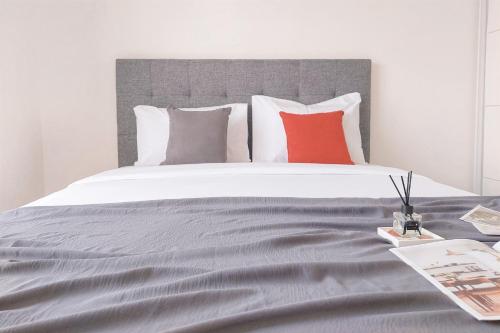 a bedroom with a large bed with red pillows at Good Choice and Comfy 2BR Sky House BSD Apartment By Travelio in Tangerang