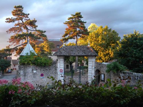 a stone building with a gate and trees at Le Val d'Amby in Hières-sur-Amby