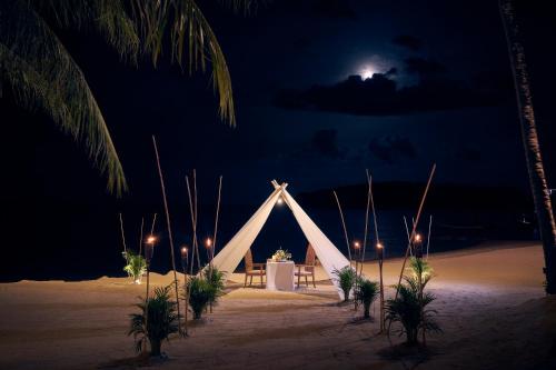 a white tent on the beach at night at Anantara Lawana Koh Samui Resort in Chaweng