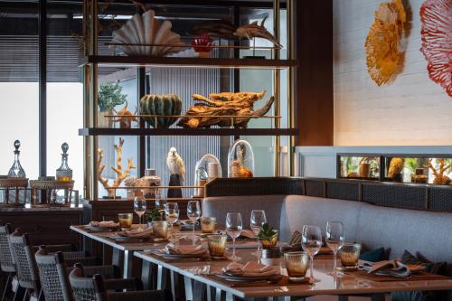 a dining room with a long table with glasses at Anantara Lawana Koh Samui Resort in Chaweng