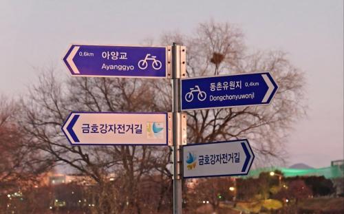 a street sign with signs in an asian language at House of Gallery Hyomok in Daegu