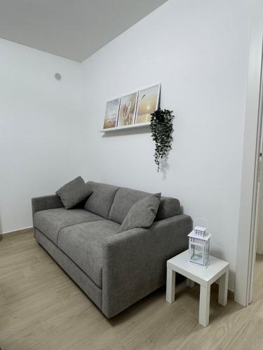 a living room with a gray couch and a table at HilMar Holiday Home in SantʼAgata di Militello