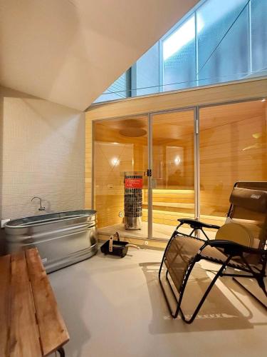a room with a bench and a table and some glass at MitO Onomichi - Sauna & Scenic 3-Story Stay in Kaneyoshi