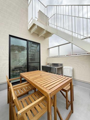 a wooden table and bench in a room at MitO Onomichi - Sauna & Scenic 3-Story Stay in Kaneyoshi