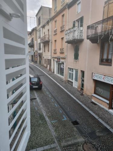 a car driving down a street with buildings at L'instant cosy, t2 bourg de Royat in Royat