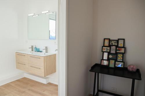 une salle de bain avec un lavabo et un miroir dans l'établissement La Maison du temps ensemble, à Mulhouse