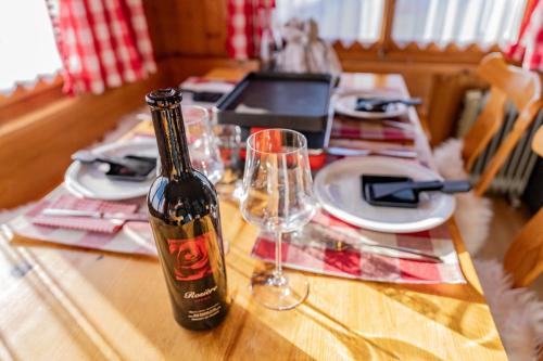 a bottle of wine sitting on a table with glasses at Ferienhaus Alpsteinsicht in Appenzell