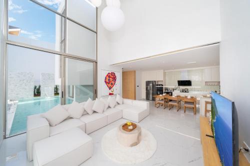 a living room with white furniture and a pool at Your Private Piece of Paradise! 4BR Pool Villa in the New Lux Pride 2 V9 Residence in Bang Tao Beach