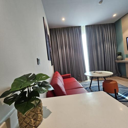a living room with a red couch and a table at Swiss-Belinn Airport Muscat Oman in Muscat