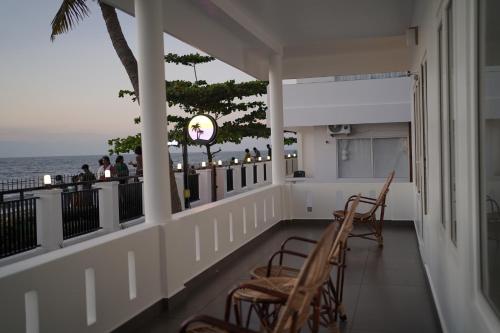 a balcony with chairs and a view of the ocean at Golden Sands Cherai in Cherai Beach
