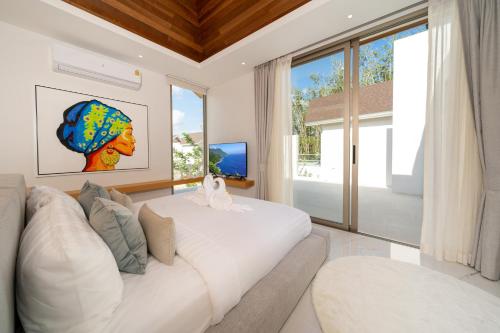 a living room with a white couch and a large window at Your Private Piece of Paradise! 4BR Pool Villa in the New Lux Pride 2 V9 Residence in Ban Pak Lak