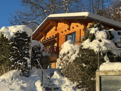 a house covered in snow in front at Chalet 7 Luxury Chalet with Cinema room in Crans-Montana