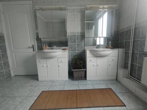 une salle de bain avec deux lavabos et un miroir dans l'établissement Maisonlille, à Lille