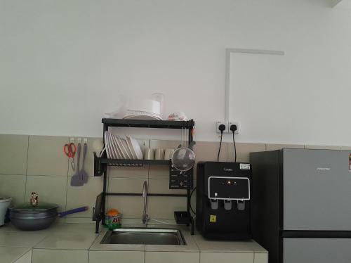 a kitchen with a sink and a refrigerator at Zayyan Homestay Parit Buntar in Parit Buntar