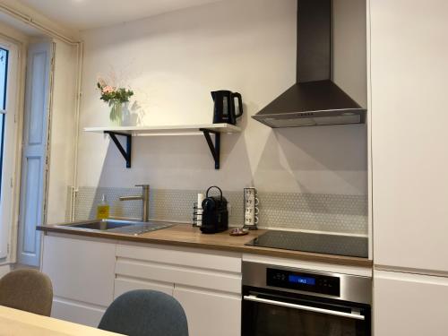 une cuisine avec un évier et une cuisinière dans l'établissement Studio cosy, proche gare, à Nantes