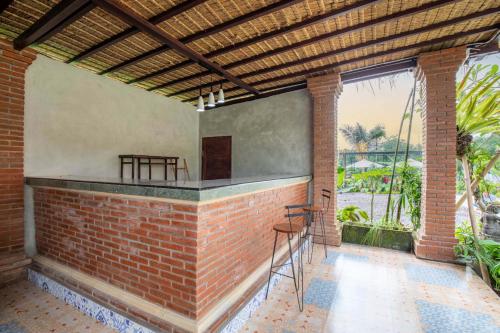 an outdoor bar with chairs and a brick wall at The Hidden Valley in Besakih
