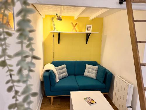 un salon avec un canapé bleu et une table dans l'établissement Studio cosy, proche gare, à Nantes