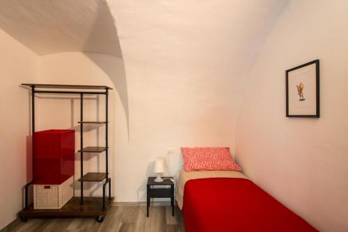 a bedroom with a red bed and a shelf at Casa Margherita PT, Borno Ospitar in Borno