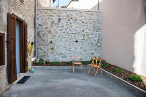 two chairs sitting on a patio next to a building at Casa Margherita PT, Borno Ospitar in Borno