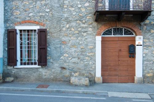 a building with a wooden door and a balcony at Casa Margherita PT, Borno Ospitar in Borno